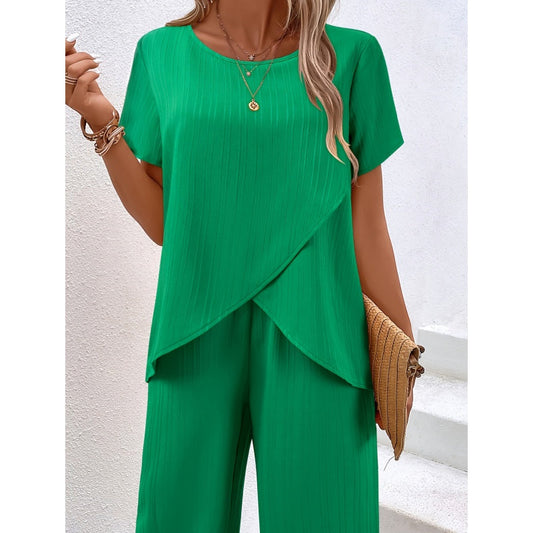 En outfit för kvinnor bestående av en ledig asymmetrisk topp och byxor med vida ben