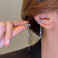 Minimalistisk öronmanschett med strass och tofs